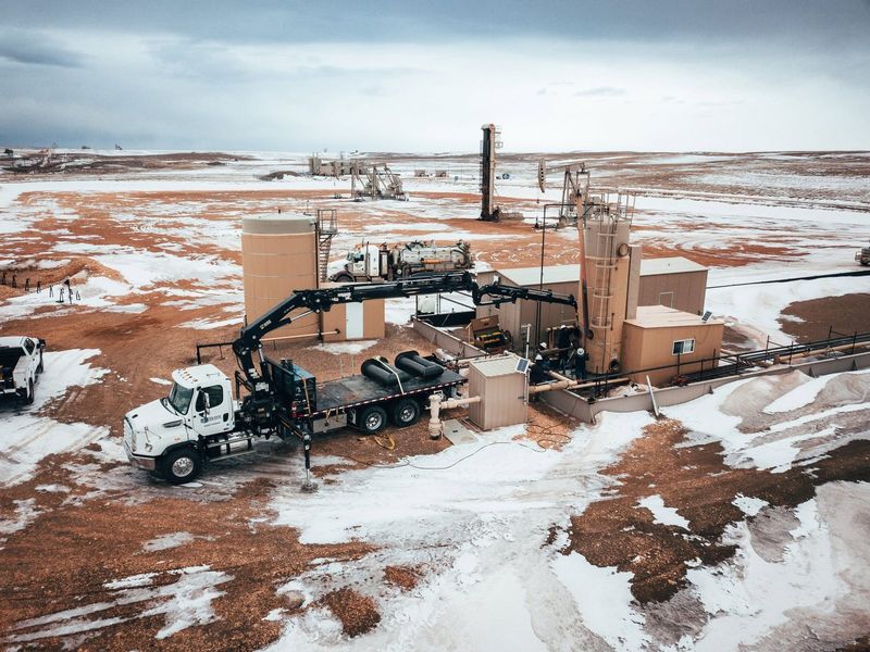 Elite crane truck working a facility, seen from the air