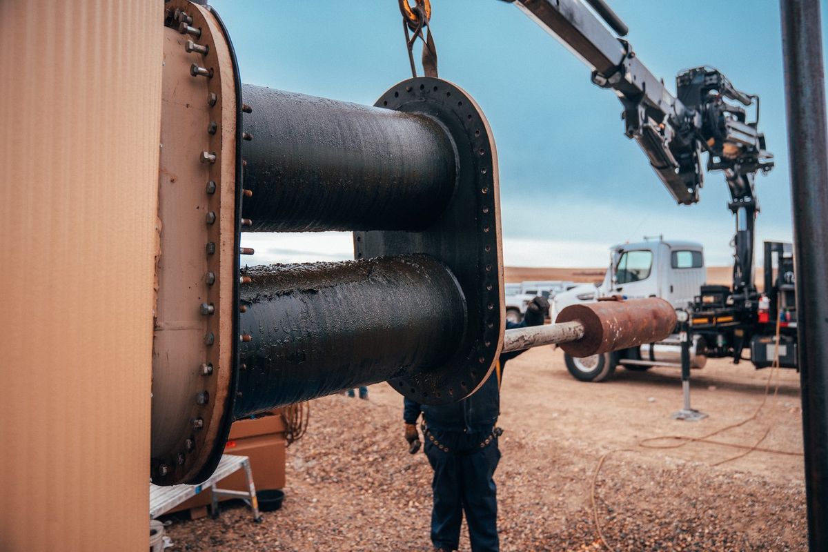 Crane truck lifting a spent fire tube out of a heater treater